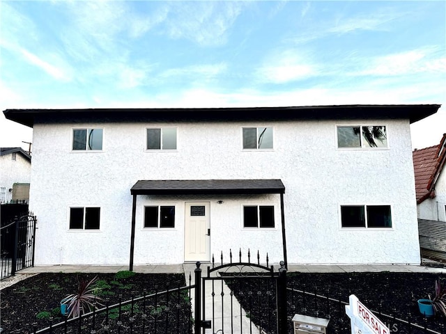 view of front of home with fence and stucco siding