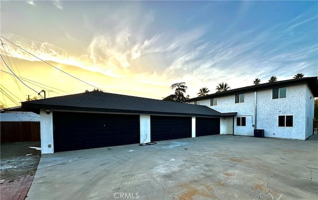 exterior space with a garage, concrete driveway, and stucco siding