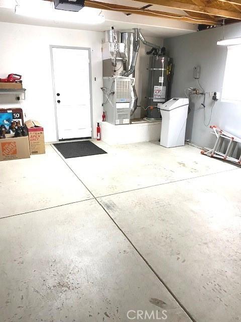 garage featuring heating unit and secured water heater