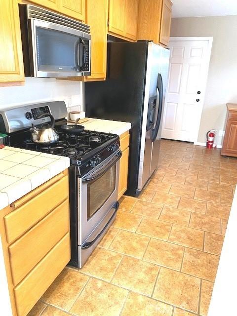 kitchen featuring appliances with stainless steel finishes and tile countertops