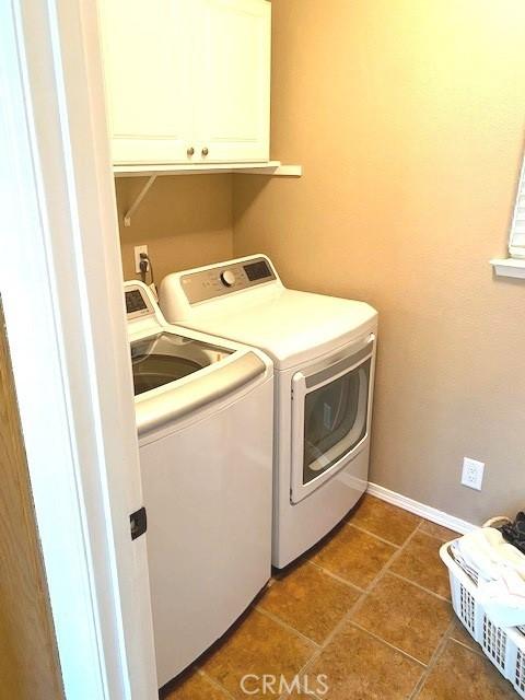 washroom featuring cabinets and washer and clothes dryer