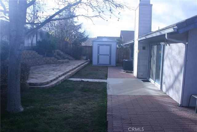 view of yard with a storage shed, a patio area, and central AC