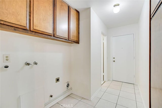 clothes washing area with cabinets, light tile patterned floors, gas dryer hookup, and hookup for an electric dryer