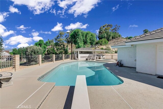 view of pool featuring a diving board, a gazebo, a jacuzzi, and a patio