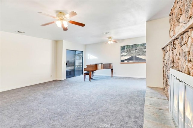 interior space featuring ceiling fan, light colored carpet, and a fireplace