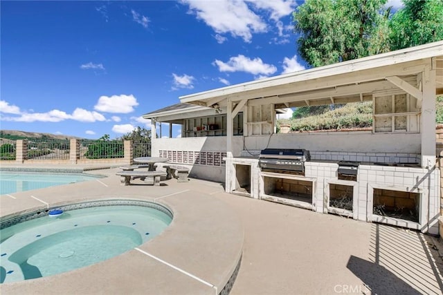 view of swimming pool featuring a patio area, an outdoor kitchen, and area for grilling