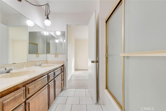 bathroom with combined bath / shower with glass door, vanity, and tile patterned flooring