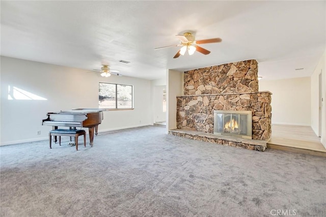 carpeted living room with ceiling fan and a fireplace