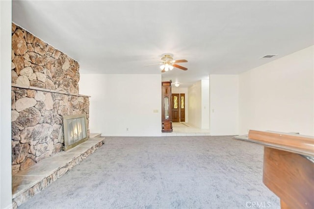 unfurnished living room with light colored carpet, a fireplace, and ceiling fan