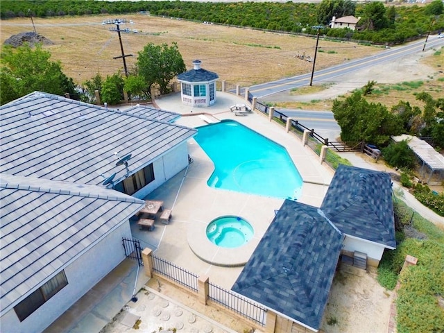 view of pool with a patio area, an outbuilding, and an in ground hot tub