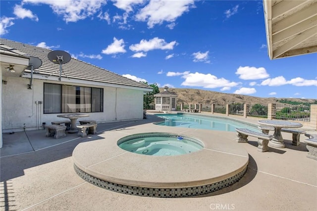 view of swimming pool featuring a mountain view, an in ground hot tub, and a patio