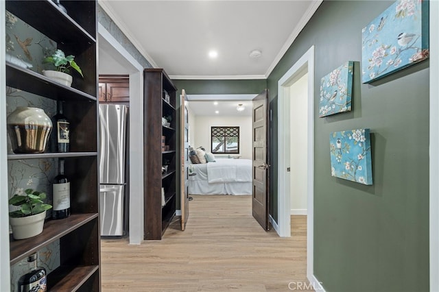 corridor featuring light wood-type flooring and ornamental molding