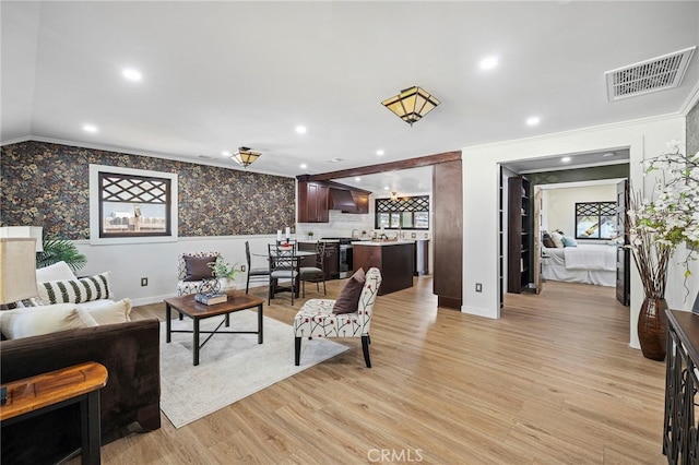 living room with crown molding and light hardwood / wood-style flooring