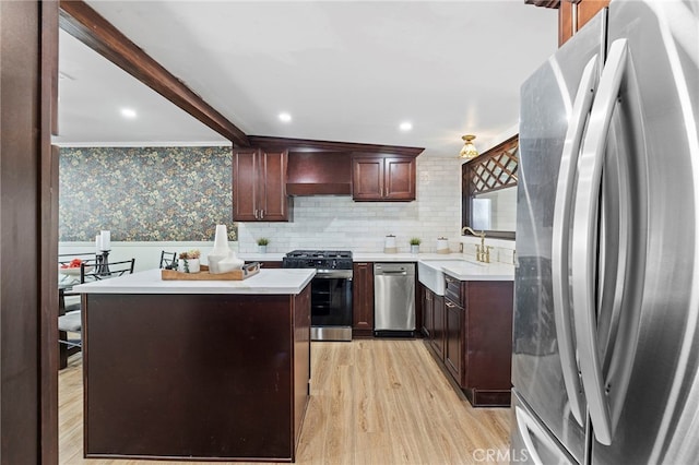 kitchen featuring appliances with stainless steel finishes, custom range hood, a kitchen island, light hardwood / wood-style flooring, and sink