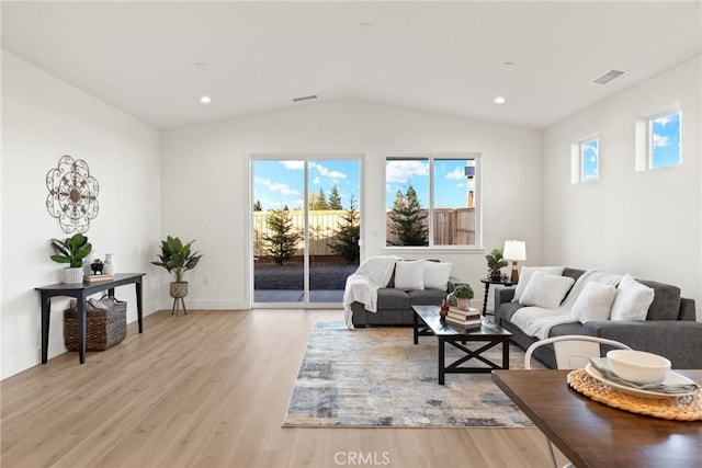 living room featuring vaulted ceiling and light wood-type flooring