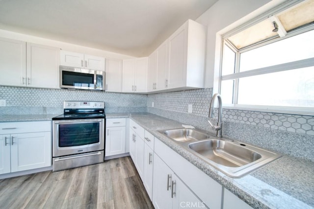 kitchen featuring sink, white cabinetry, appliances with stainless steel finishes, and tasteful backsplash