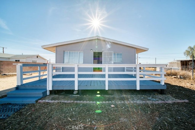 rear view of property featuring a wooden deck