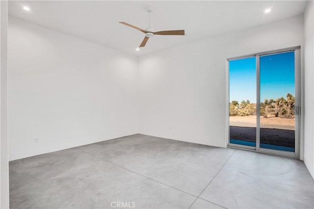 spare room with ceiling fan and concrete flooring