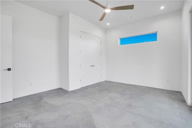 empty room with ceiling fan and concrete floors