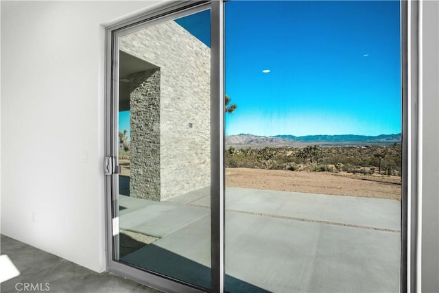 doorway featuring concrete flooring and a mountain view