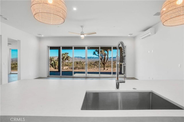 kitchen with ceiling fan, sink, and a wall unit AC