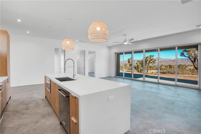 kitchen with a center island with sink, ceiling fan, pendant lighting, stainless steel dishwasher, and sink