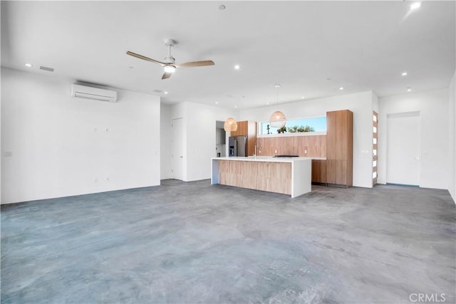 unfurnished living room featuring ceiling fan, sink, and a wall unit AC