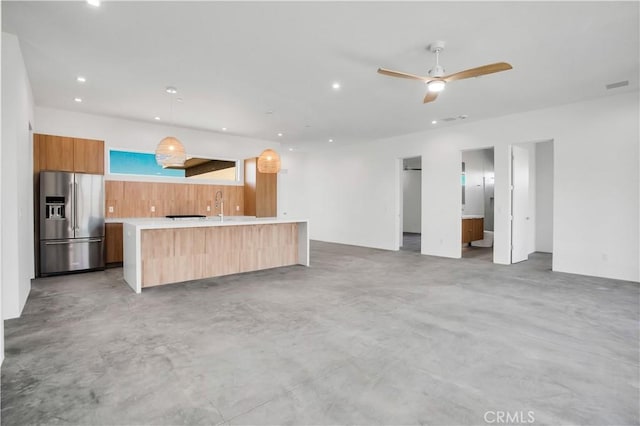 kitchen with ceiling fan, sink, hanging light fixtures, and stainless steel fridge with ice dispenser