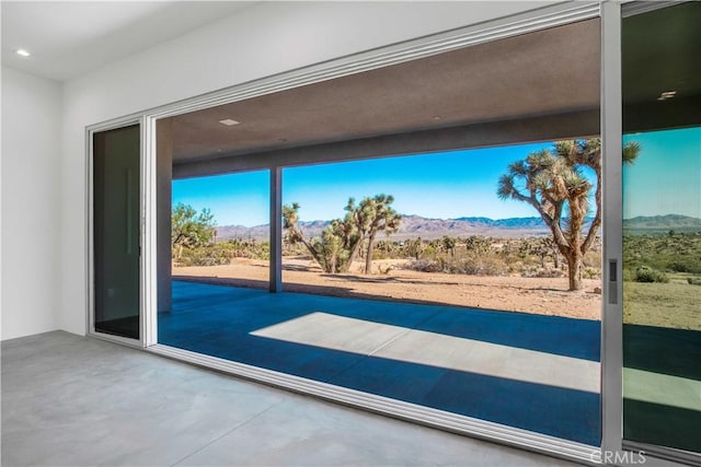 doorway with a mountain view and concrete floors