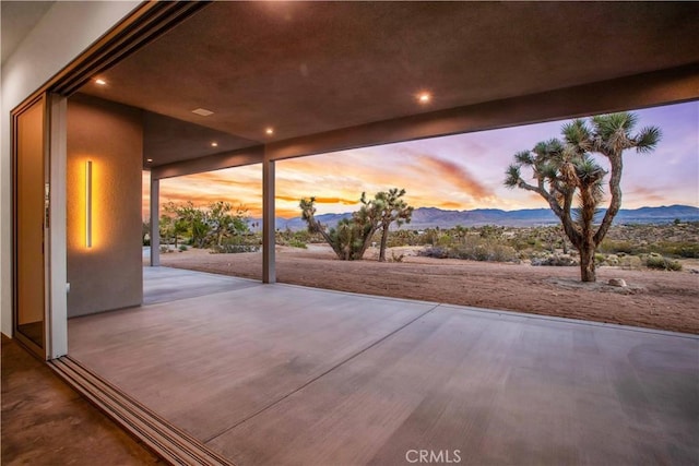 patio terrace at dusk featuring a mountain view