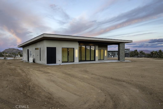 back house at dusk featuring a mountain view