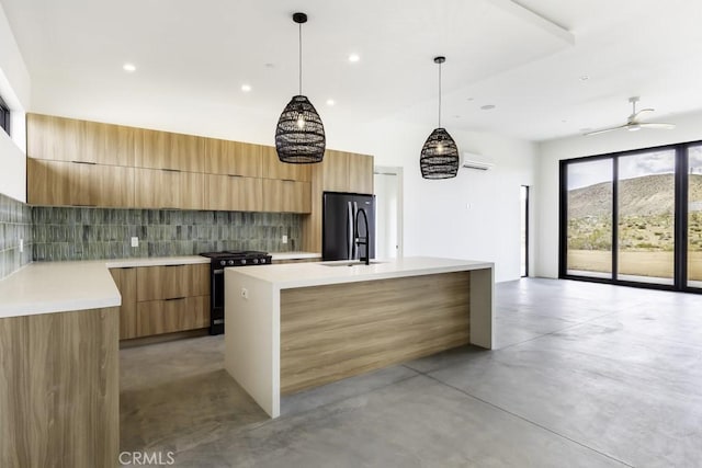 kitchen featuring ceiling fan, tasteful backsplash, a center island with sink, black appliances, and hanging light fixtures