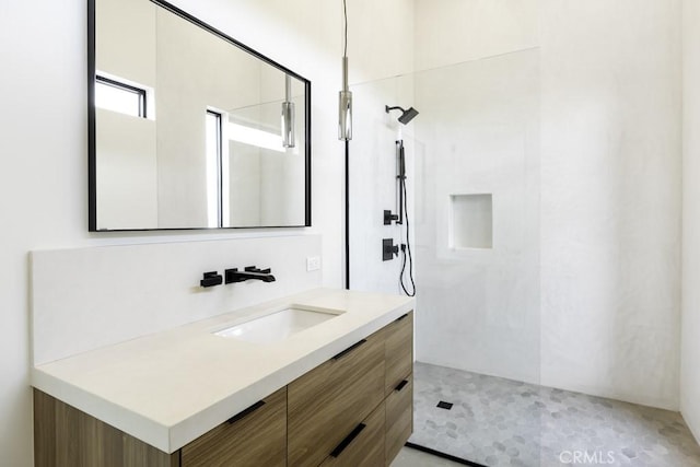 bathroom with vanity and a tile shower