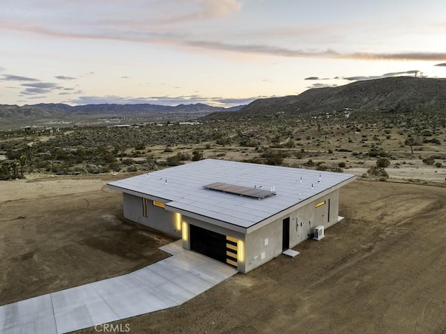 aerial view at dusk featuring a mountain view