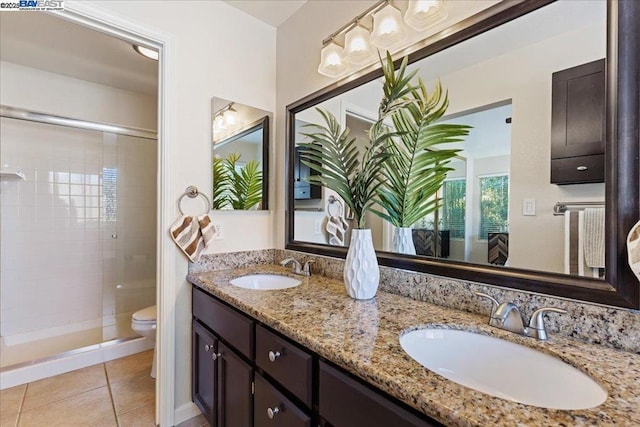 bathroom featuring vanity, tile patterned floors, toilet, and tiled shower