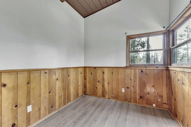 empty room featuring wooden ceiling, vaulted ceiling, and light hardwood / wood-style floors