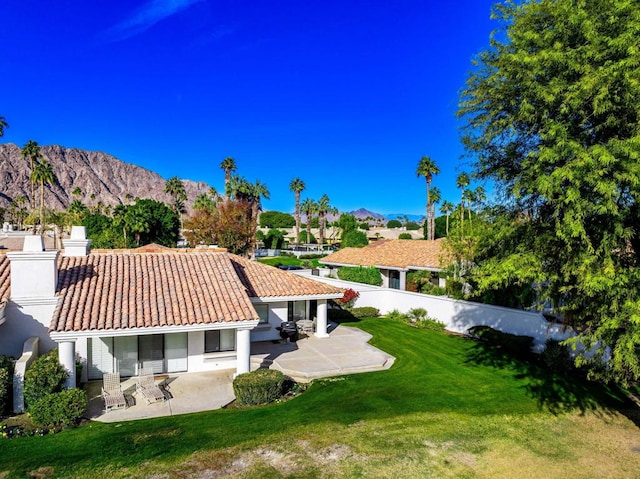 exterior space featuring a patio area, a mountain view, and a yard