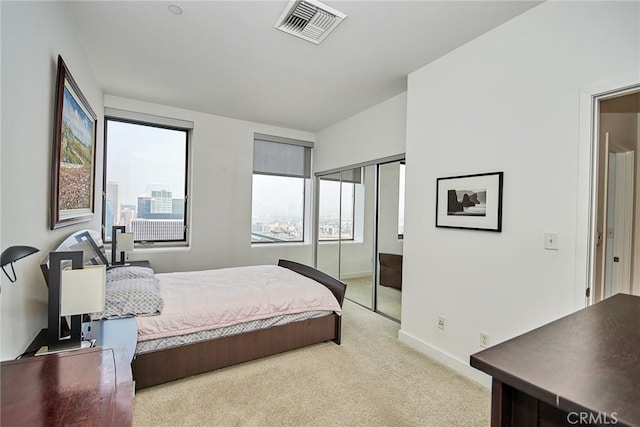 bedroom featuring light carpet and a closet