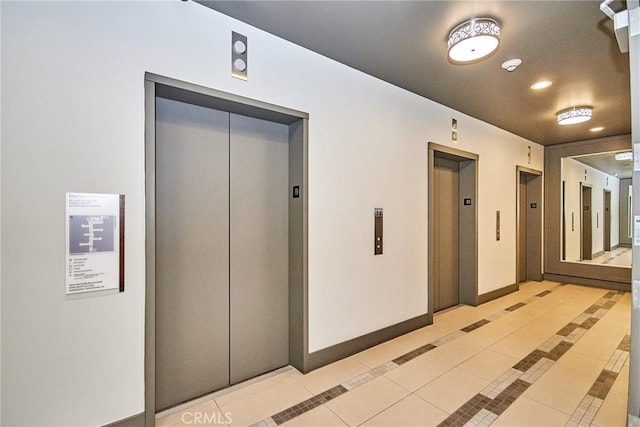 hall with light tile patterned flooring and elevator