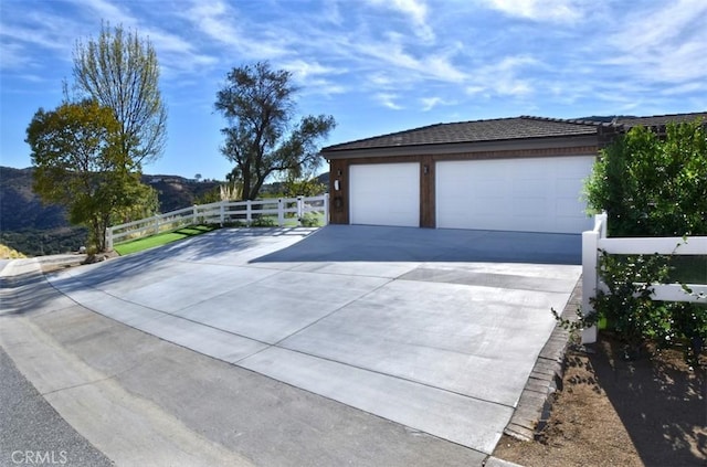 garage featuring fence and driveway