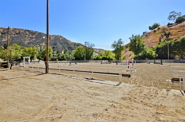 exterior space with an enclosed area, a rural view, and a mountain view