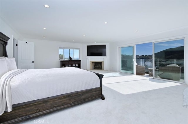 bedroom with crown molding, recessed lighting, a fireplace, and access to exterior