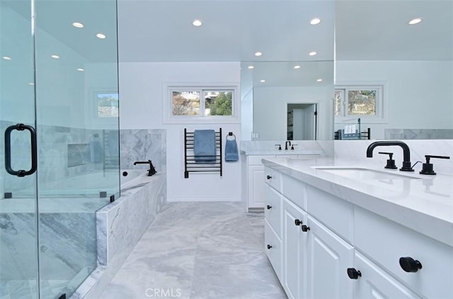 bathroom featuring a garden tub, recessed lighting, a sink, a shower stall, and double vanity