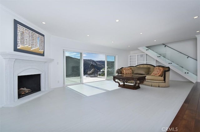 living room with a fireplace with raised hearth and recessed lighting