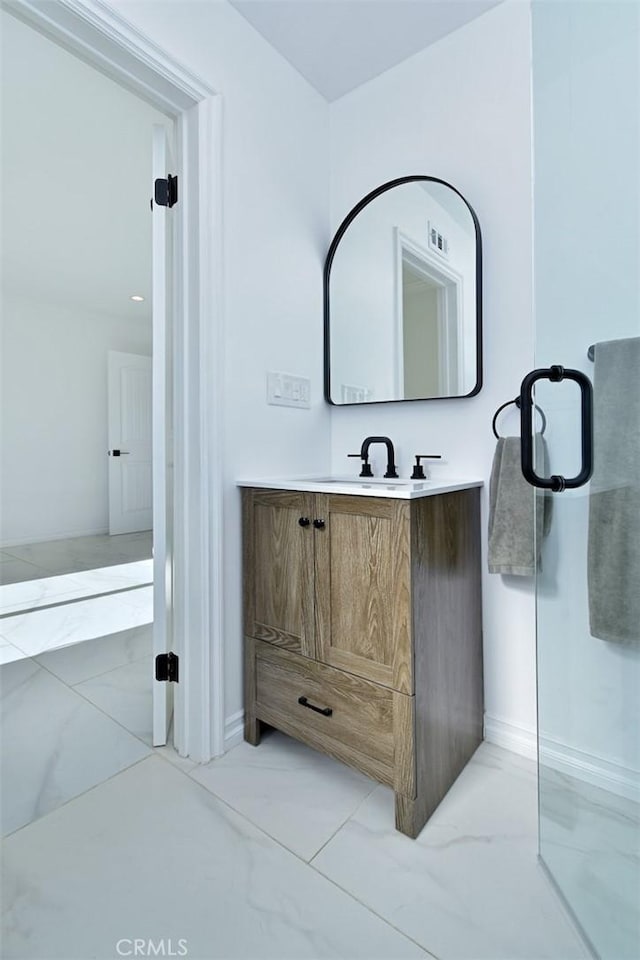 bathroom with marble finish floor, baseboards, and vanity