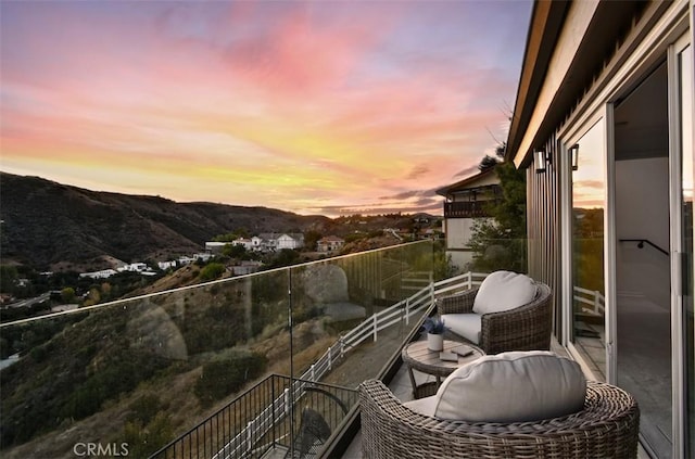 balcony at dusk featuring a mountain view