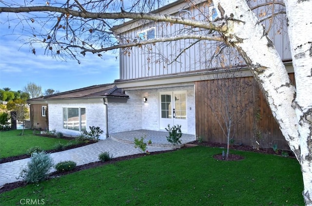 view of front of property featuring a front lawn and a patio