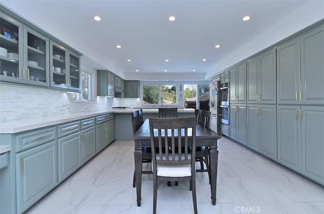 kitchen with double oven, backsplash, and gray cabinets