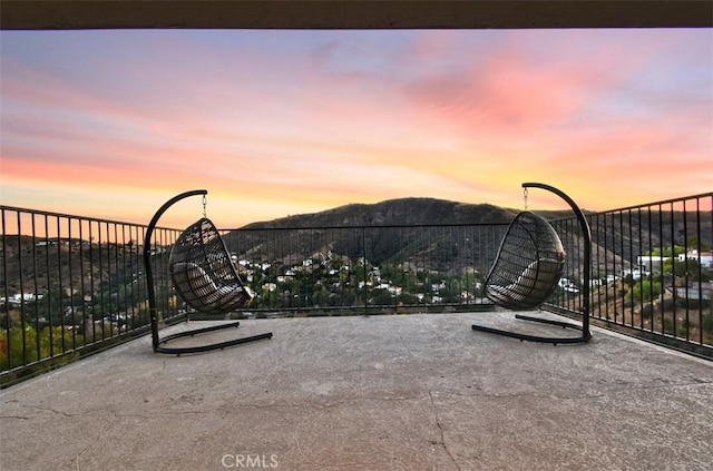 patio terrace at dusk featuring a mountain view