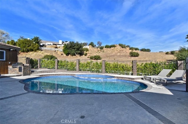 view of pool featuring a patio area, fence, and area for grilling